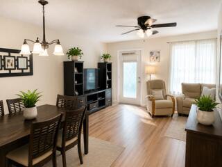 A dining room features a dark wood table and chairs on a light area rug — 108 Greenbrier, West Palm Beach FL 33417, WEST PALM BEACH, FL