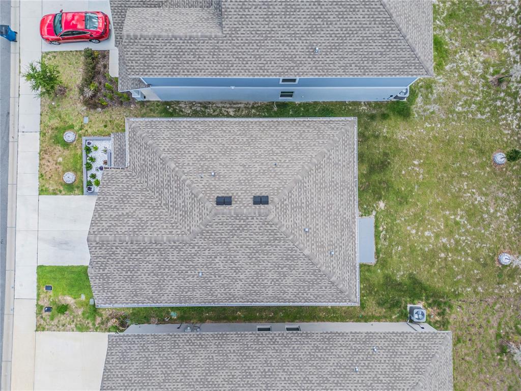 An aerial view shows the roof of a house situated between two neighboring homes — 2158 AQUIFER LANE, DAVENPORT, FL