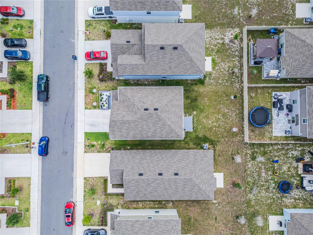 An aerial view shows several suburban houses with driveways and backyards along a paved street — 2158 AQUIFER LANE, DAVENPORT, FL