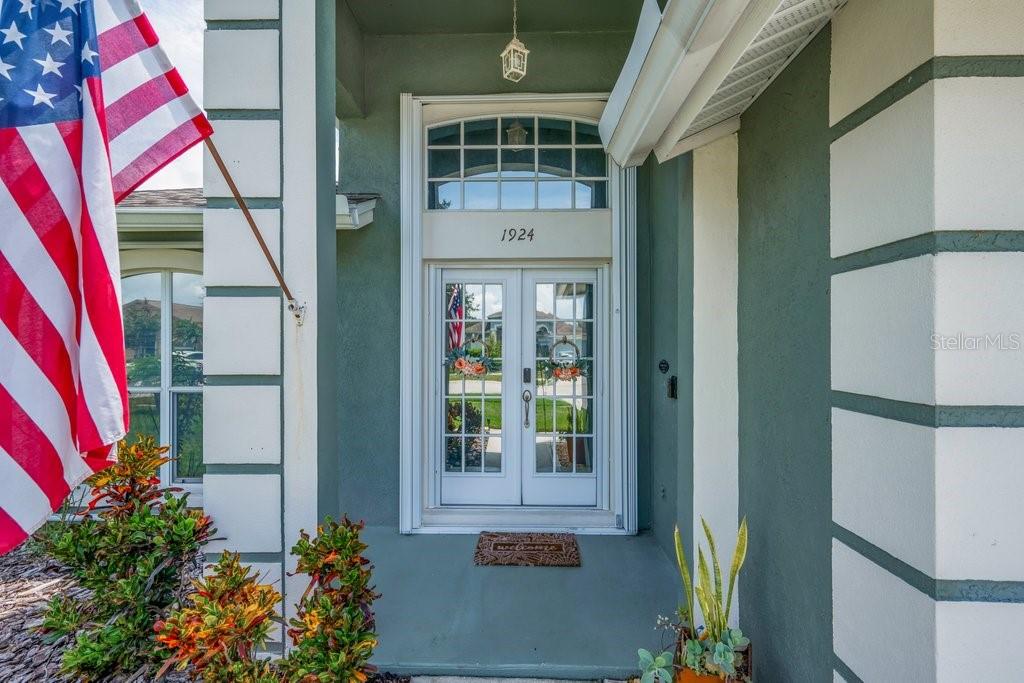 A front entryway features a double glass door, a transom window, and an American flag — 1924 SEDGEFIELD STREET, BRANDON, FL