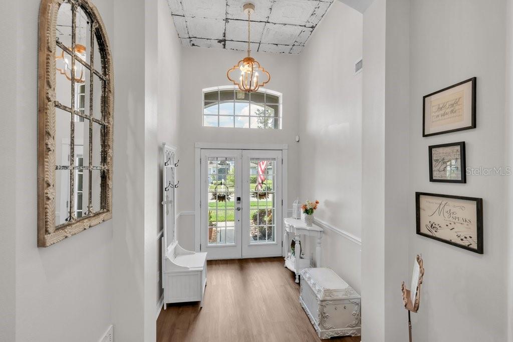 A bright entryway features a high ceiling with a tin tile finish and double glass doors — 1924 SEDGEFIELD STREET, BRANDON, FL