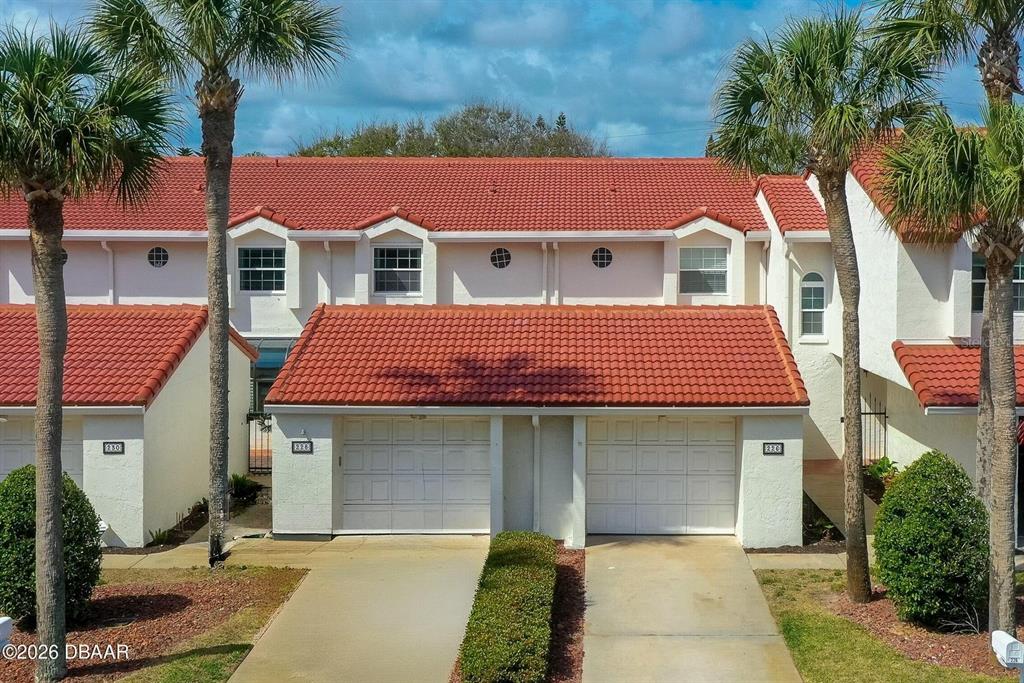 An exterior view of a multi-unit townhouse complex with red tile roofs and garages — 226 FLORIDA SHORES BOULEVARD, DAYTONA BEACH, FL