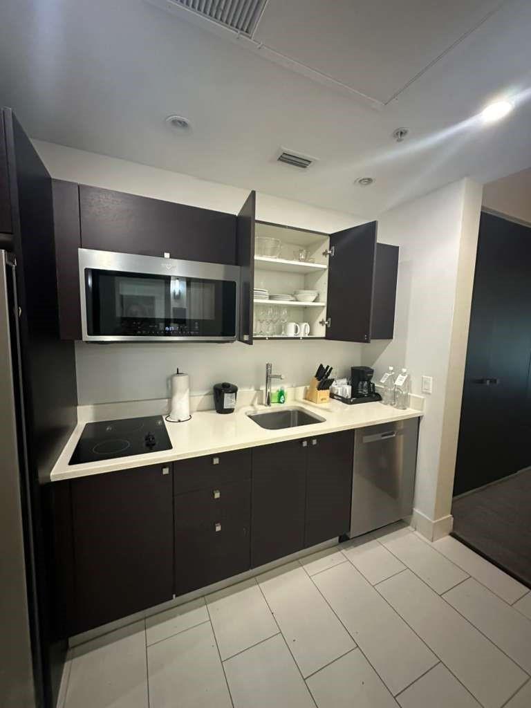 A modern kitchen features dark wood cabinets, stainless steel appliances, and white countertops — 5300 NW 87th Avenue # 706, Miami FL 33178, MIAMI, FL