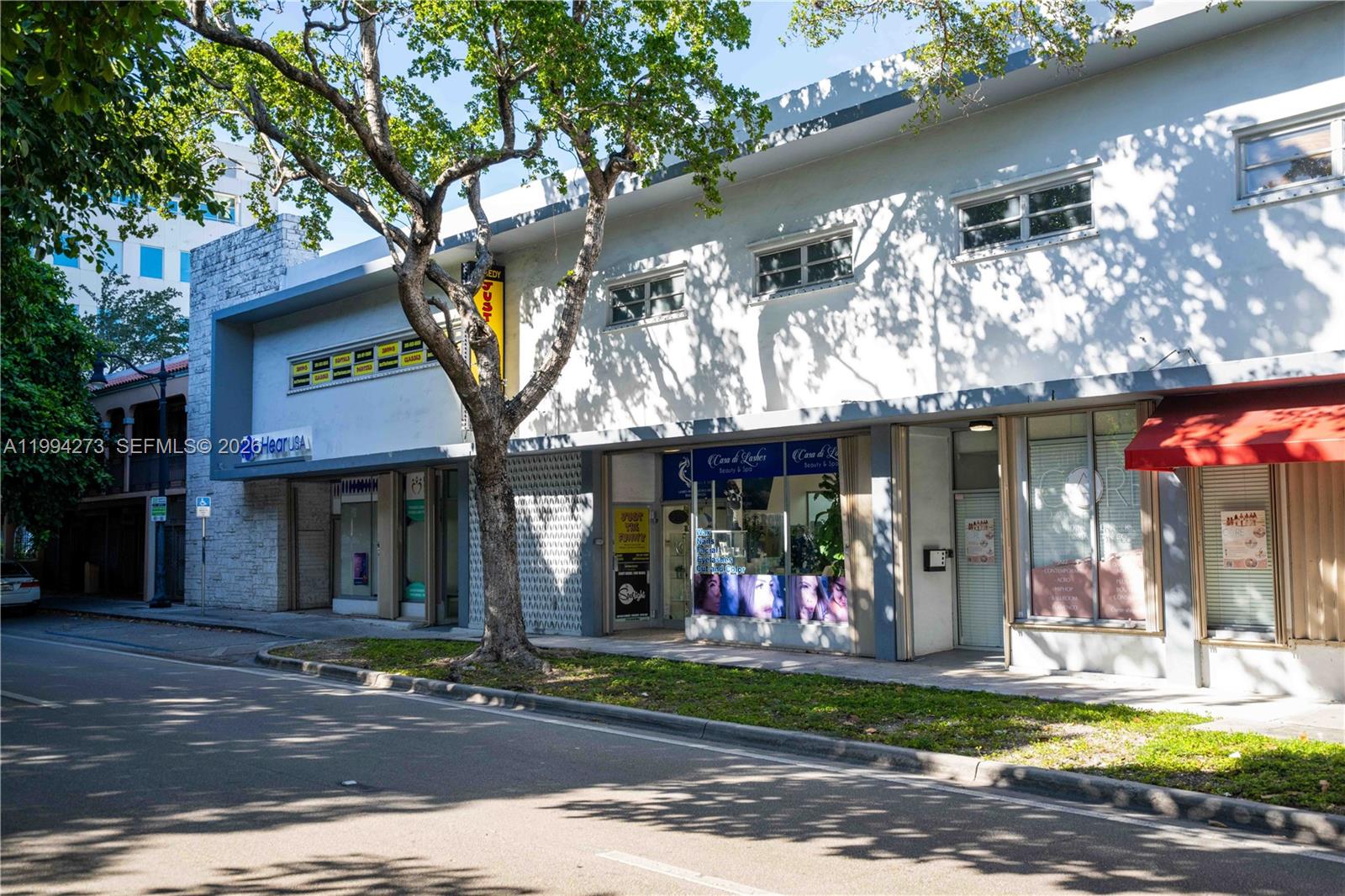A two-story commercial building with storefronts and a large tree in front — 3119 Coral Way # 200, Miami FL 33145, MIAMI, FL