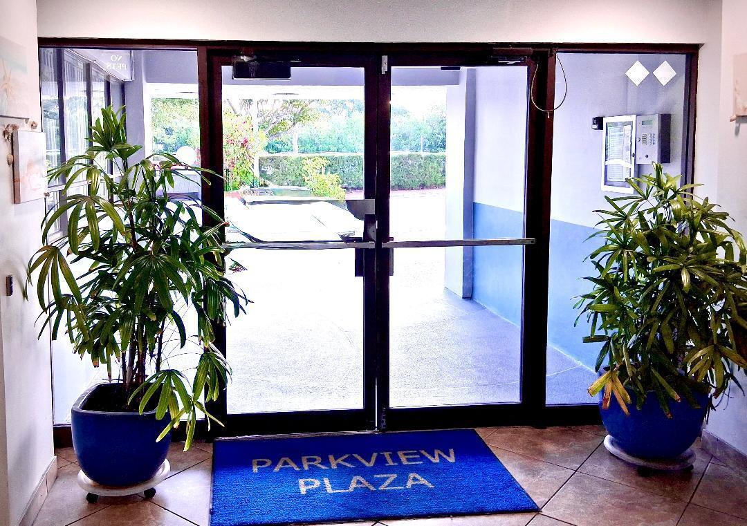 A glass double door entrance with potted plants and a blue Parkview Plaza floor mat — 7300 Wayne Avenue # 213, Miami Beach FL 33141, MIAMI BEACH, FL