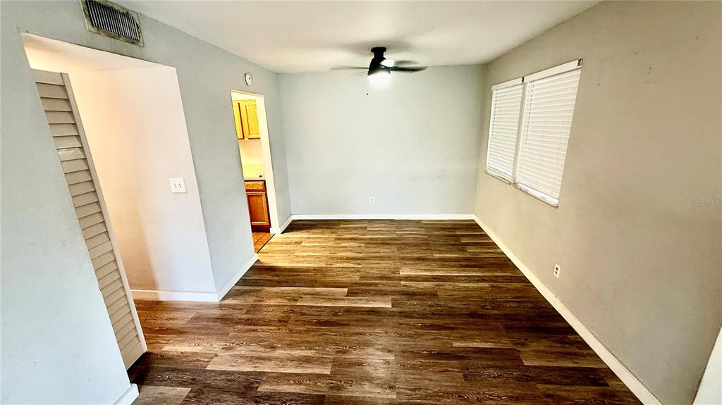 An empty room features light gray walls, wood-look flooring, and a ceiling fan — 6519 W NEWBERRY ROAD UNIT 812, GAINESVILLE, FL