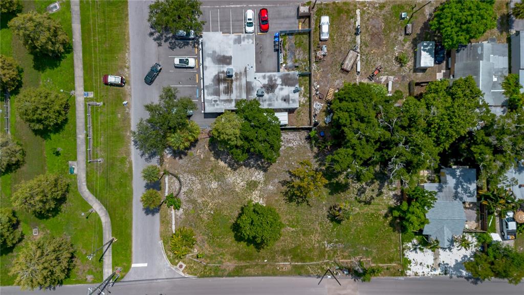 An aerial view shows a commercial building with a parking lot and an adjacent vacant lot — 5020 TANGERINE AVENUE S, GULFPORT, FL