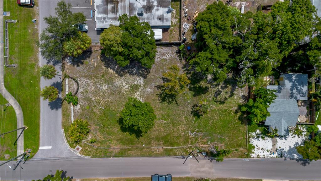 An aerial view shows a vacant, grassy lot with several trees bordered by a road — 5020 TANGERINE AVENUE S, GULFPORT, FL