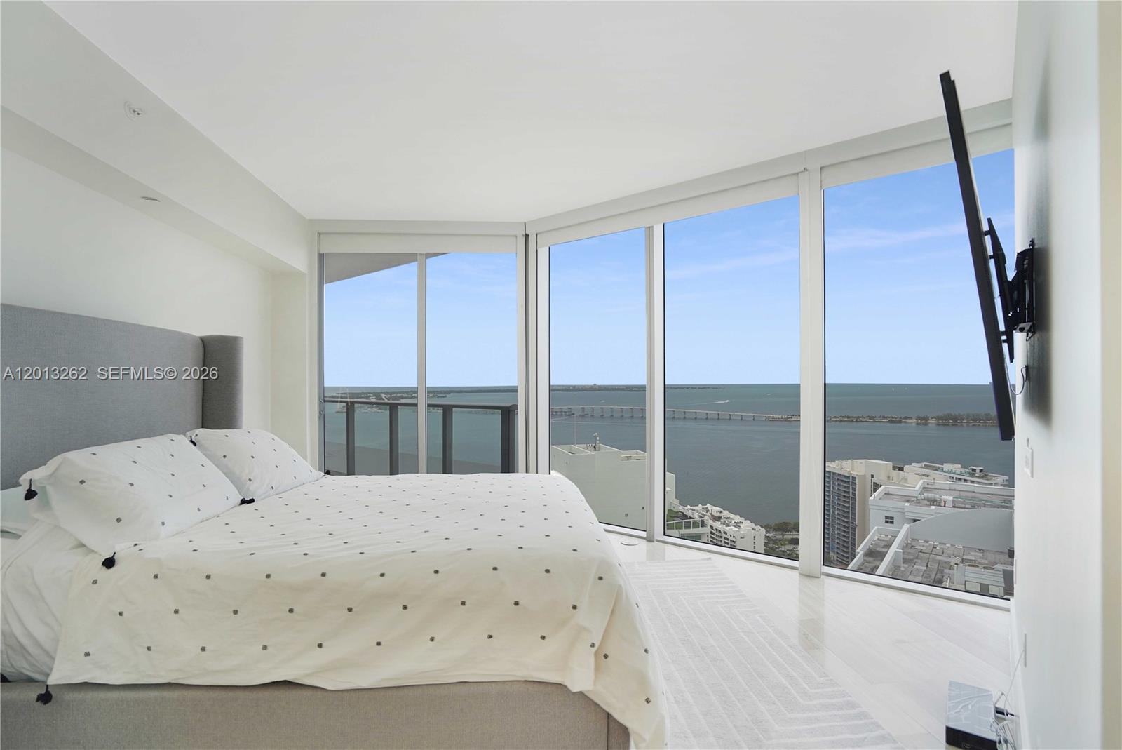 A bedroom with a large bed and floor-to-ceiling windows overlooking a bay and bridge — 1300 Brickell Bay Dr # 3402, Miami FL 33131, MIAMI, FL
