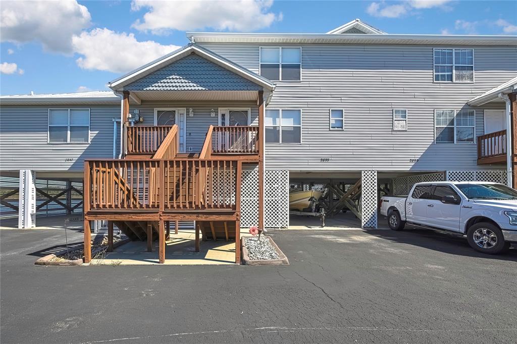 An elevated multi-unit building features a wooden staircase leading to a shared front porch — 2855 N RIVERS EDGE BOULEVARD UNIT 213, CRYSTAL RIVER, FL