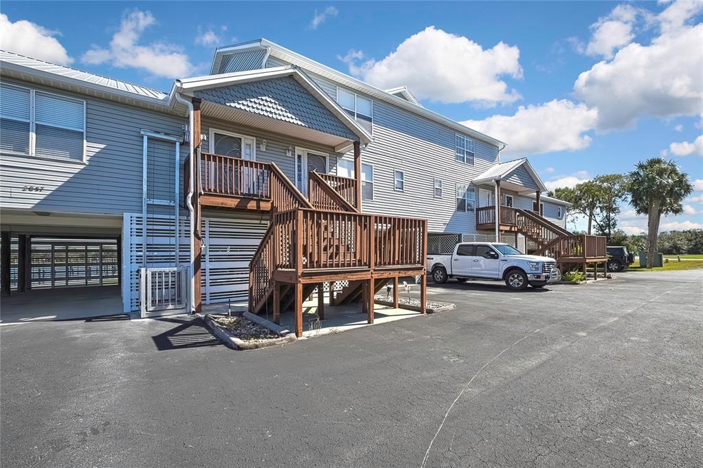 An exterior view of a multi-story residential building with elevated wooden decks and parking underneath — 2855 N RIVERS EDGE BOULEVARD UNIT 213, CRYSTAL RIVER, FL
