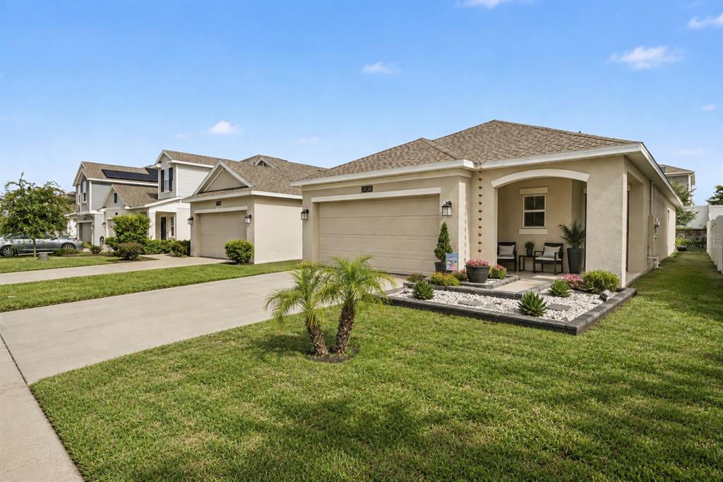 A beige single-story house with a two-car garage and a landscaped front yard — 6838 WILSON HAMMOCK AVENUE, GROVELAND, FL