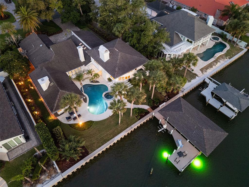 A white two-story house features a backyard swimming pool, patio furniture, and palm trees — 1215 COMMODORE DRIVE, NEW SMYRNA BEACH, FL