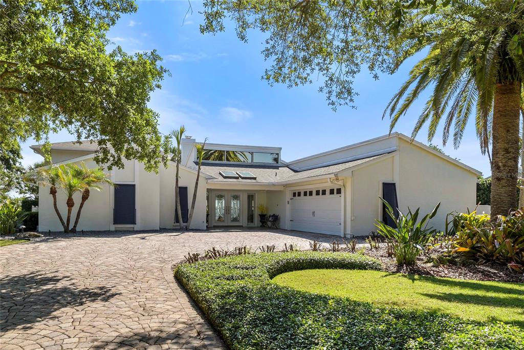 A swimming pool and hot tub sit on a patio overlooking a waterfront sunset view — 1215 COMMODORE DRIVE, NEW SMYRNA BEACH, FL