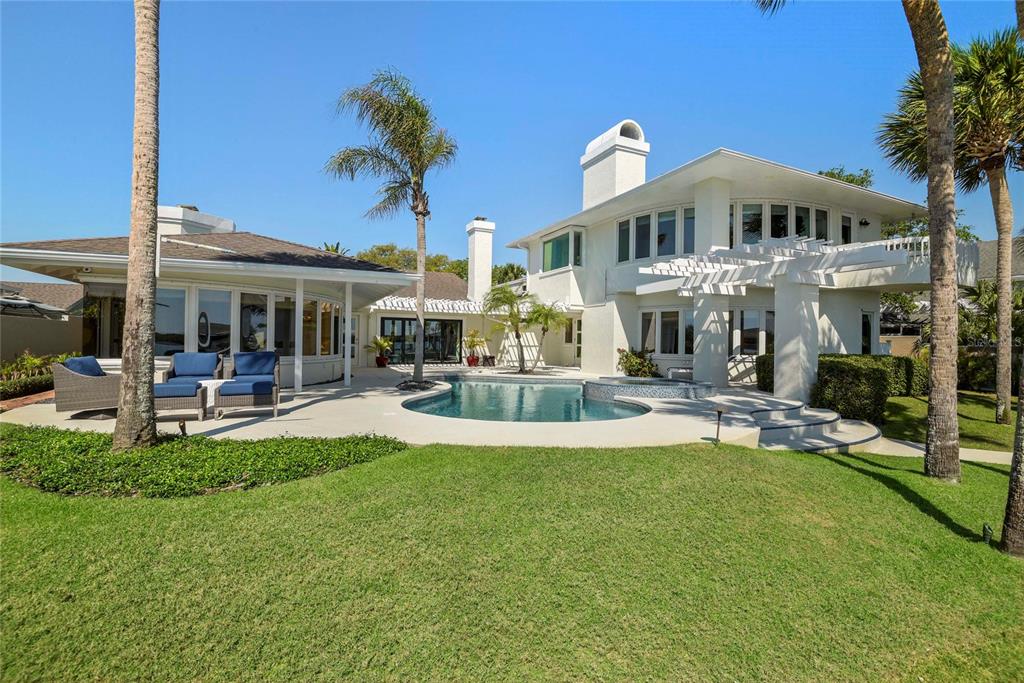 A single-story house with a paved driveway, white exterior, and a two-car garage — 1215 COMMODORE DRIVE, NEW SMYRNA BEACH, FL