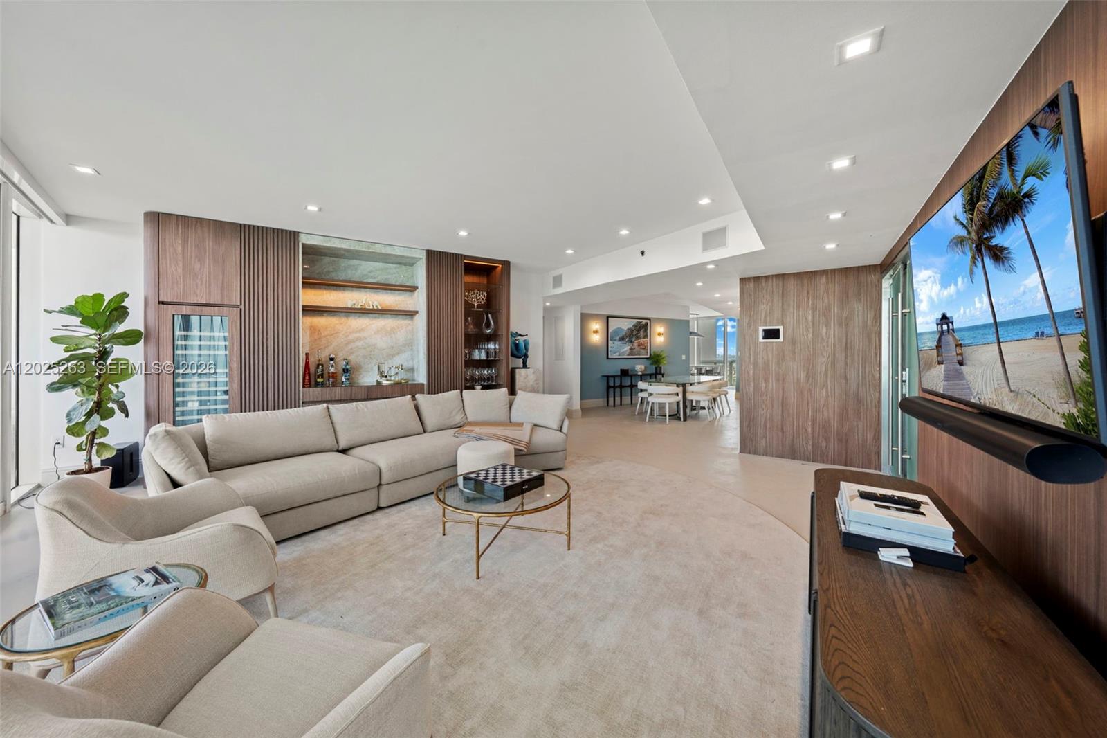 A modern living room features a large sectional sofa, wood paneling, and a television — 1000 S Pointe Dr # 2803, Miami Beach FL 33139, MIAMI BEACH, FL