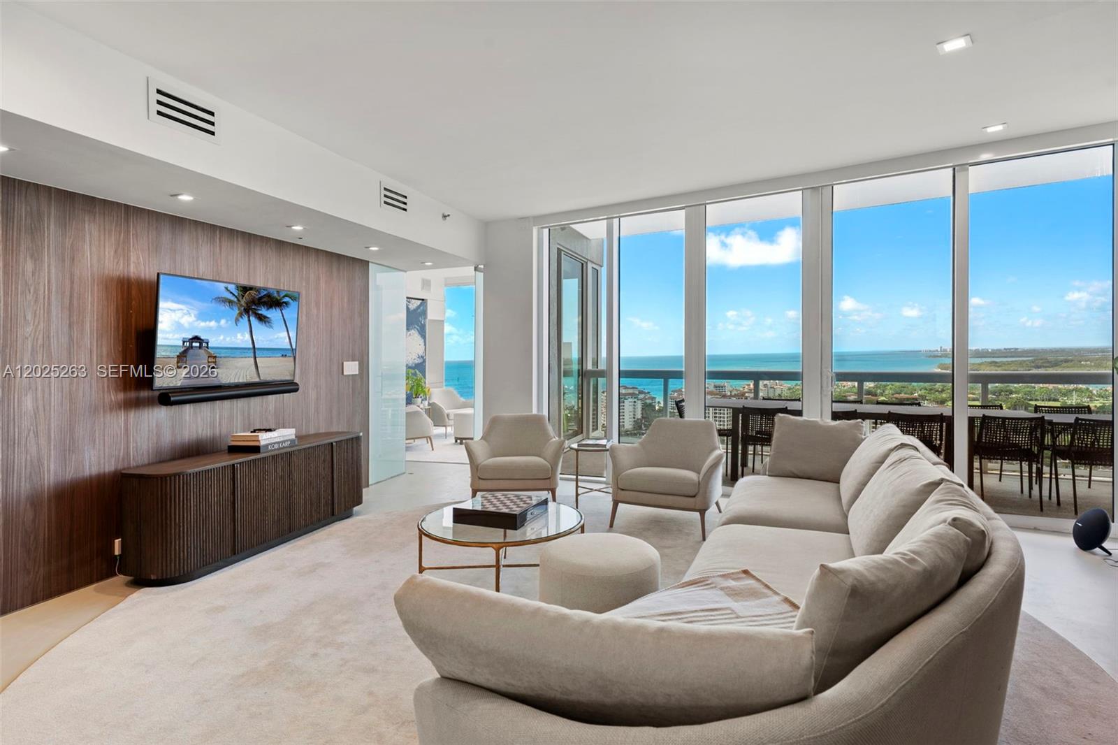 A modern living room features a wood-paneled accent wall, a large sectional, and ocean views — 1000 S Pointe Dr # 2803, Miami Beach FL 33139, MIAMI BEACH, FL