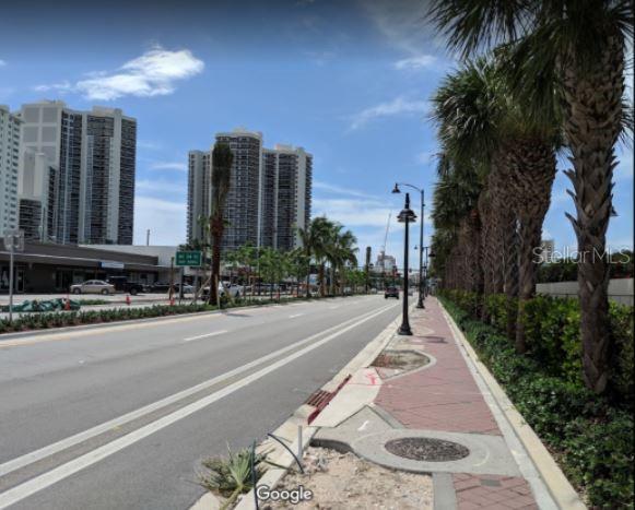 A street view shows a multi-lane road lined with palm trees and tall residential buildings — 3410 GALT OCEAN DRIVE UNIT 1406N, FORT LAUDERDALE, FL