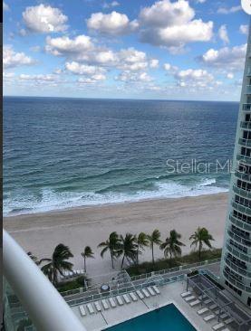 A high-angle view of a beach, ocean, and swimming pool from a balcony — 3410 GALT OCEAN DRIVE UNIT 1406N, FORT LAUDERDALE, FL