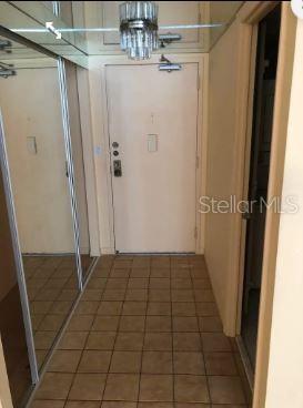 A tiled entryway features a mirrored closet door, a light fixture, and a front door — 3410 GALT OCEAN DRIVE UNIT 1406N, FORT LAUDERDALE, FL