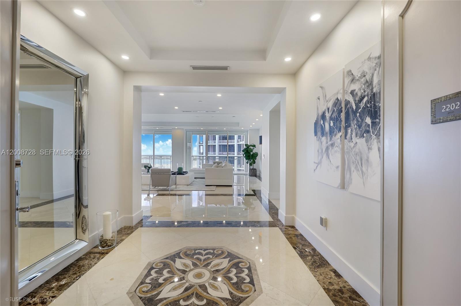 A bright foyer with marble floors and a decorative inlay leads to a living area — 3400 SW 27th Ave # 2202, Miami FL 33133, MIAMI, FL