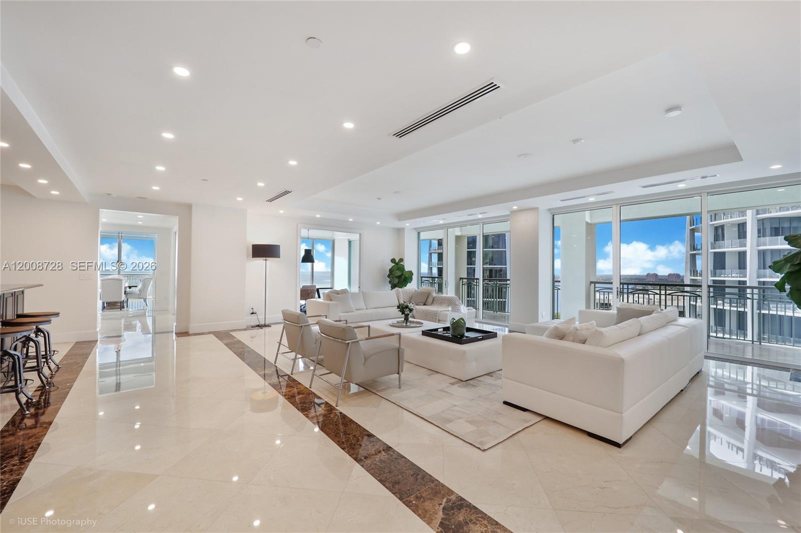 A spacious living room features white furniture, marble floors with dark borders, and floor-to-ceiling windows — 3400 SW 27th Ave # 2202, Miami FL 33133, MIAMI, FL