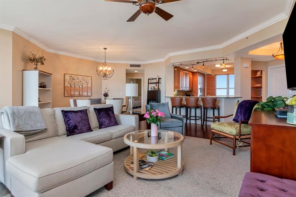 A living room with a sectional sofa, coffee table, and an open kitchen with bar seating — 5823 BOWEN DANIEL DRIVE UNIT 604, TAMPA, FL