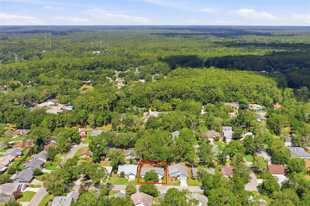 An aerial view shows a single-story house outlined in red within a wooded residential neighborhood — 6438 NW 37TH TERRACE, GAINESVILLE, FL