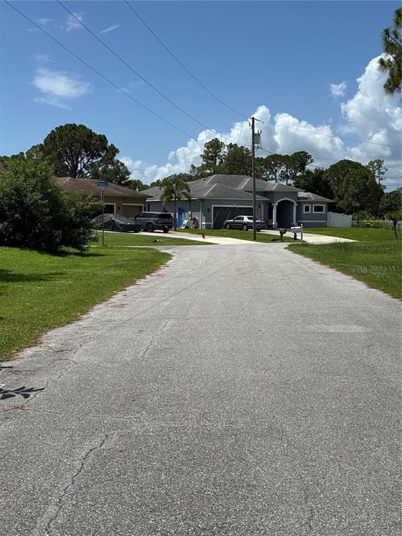 A single-story house with a stone facade sits at the end of a paved driveway — RENAULT CIRCLE, NORTH PORT, FL