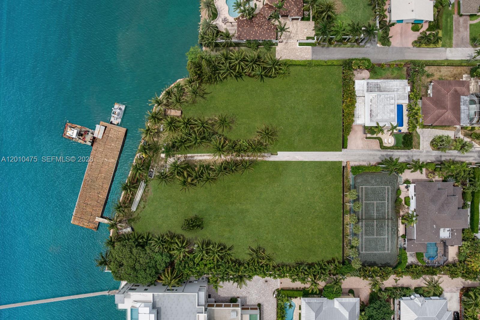 An aerial view shows two adjacent waterfront vacant lots with palm trees and a dock — 910 NE 24th St, Boca Raton FL 33431, BOCA RATON, FL