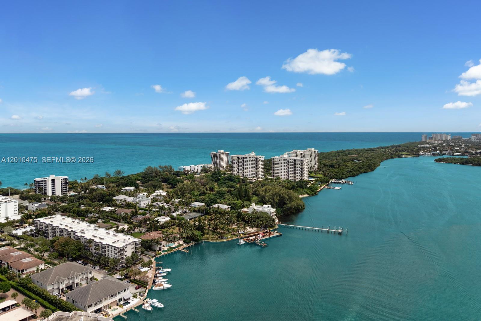 An aerial view shows a coastal residential area with high-rise buildings, houses, and a waterway — 910 NE 24th St, Boca Raton FL 33431, BOCA RATON, FL