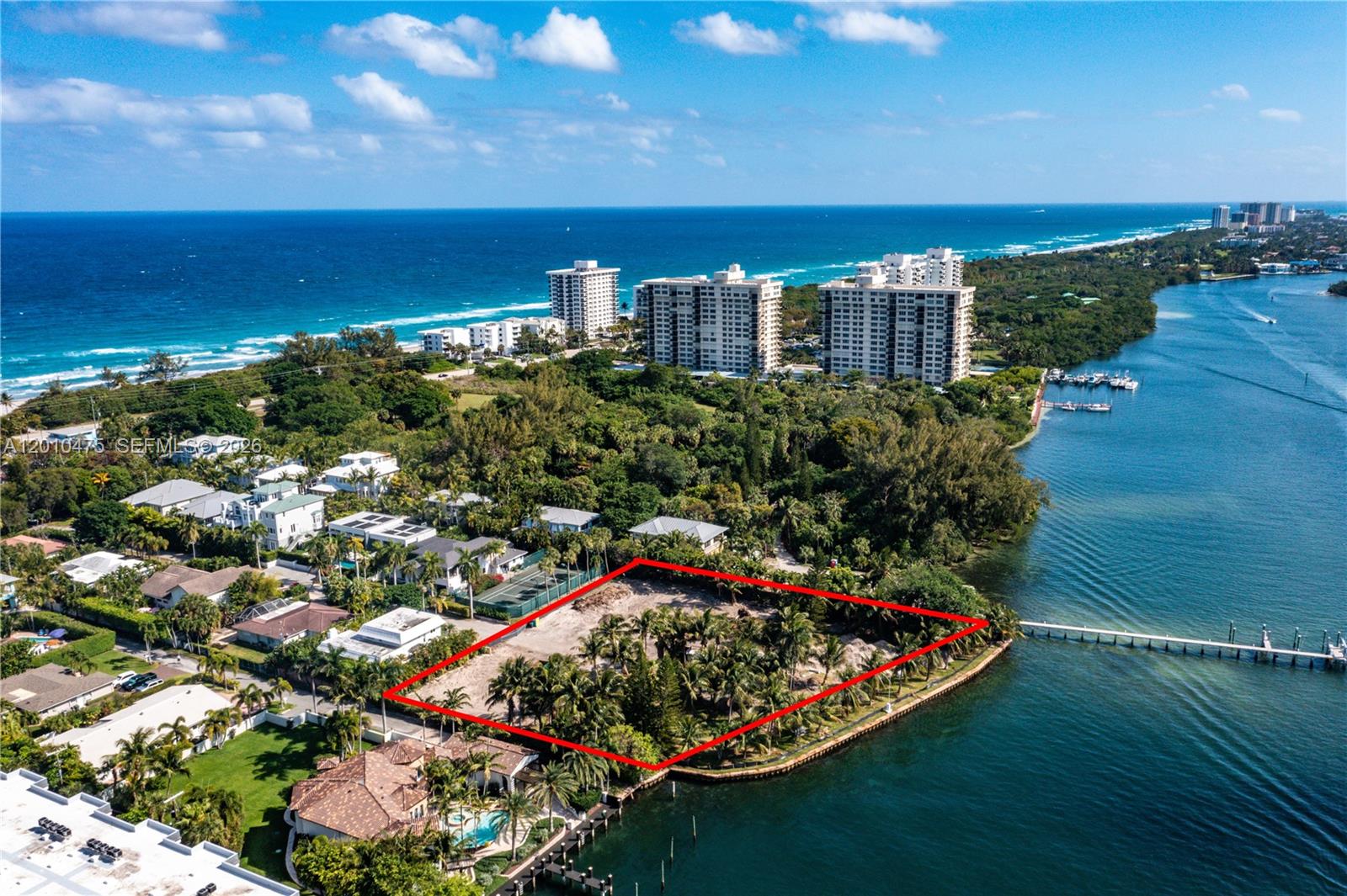 An aerial view shows a vacant waterfront lot outlined in red near a residential area — 910 NE 24th St, Boca Raton FL 33431, BOCA RATON, FL