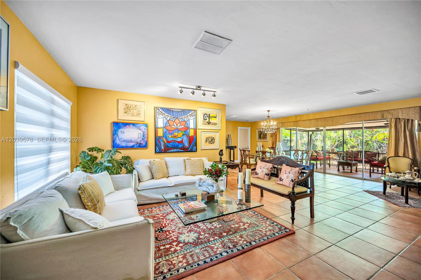 A living room features yellow walls, tile flooring, a glass coffee table, and white sofas — 8701 SW 87th Ct, Miami FL 33173, MIAMI, FL