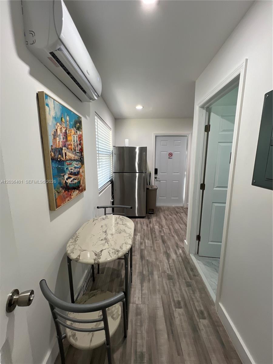 A small kitchen area features a marble-topped table, stainless steel refrigerator, and wood-look flooring — 2847 Polk St # 3, Hollywood FL 33020, HOLLYWOOD, FL