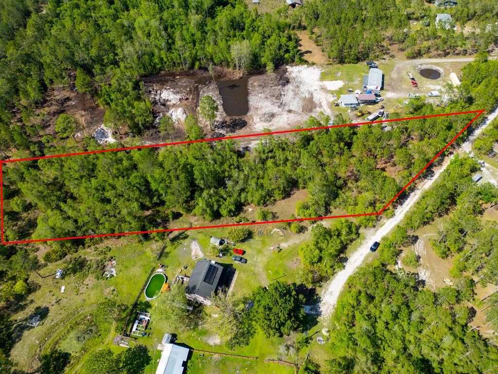 An aerial view shows a wooded lot outlined in red next to a residential property — 3770 BALSAM COURT, ORMOND BEACH, FL