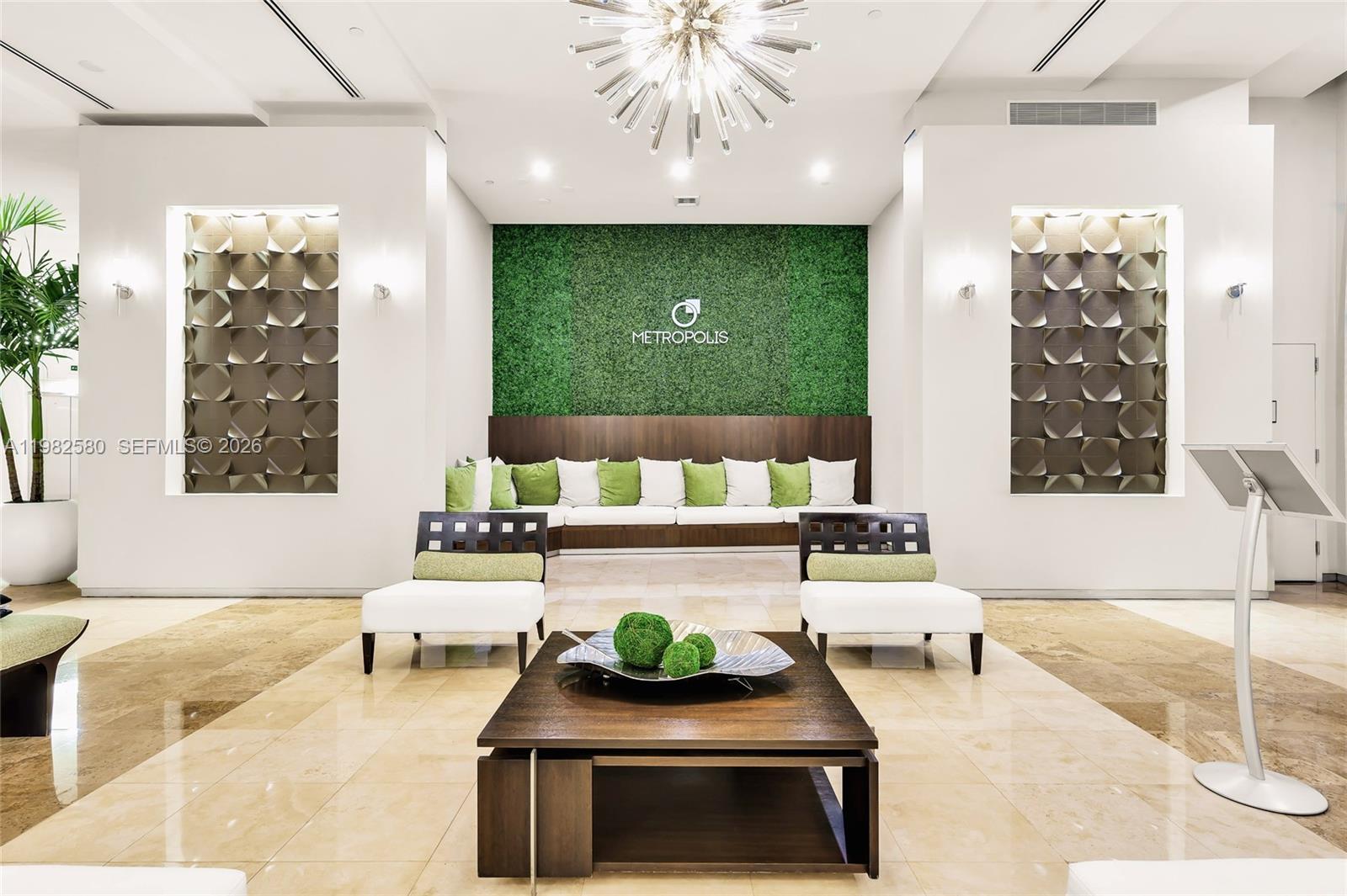 A modern lobby features a green wall, a central coffee table, and white seating — 9055 SW 73rd Ct # 1104, Miami FL 33156, MIAMI, FL