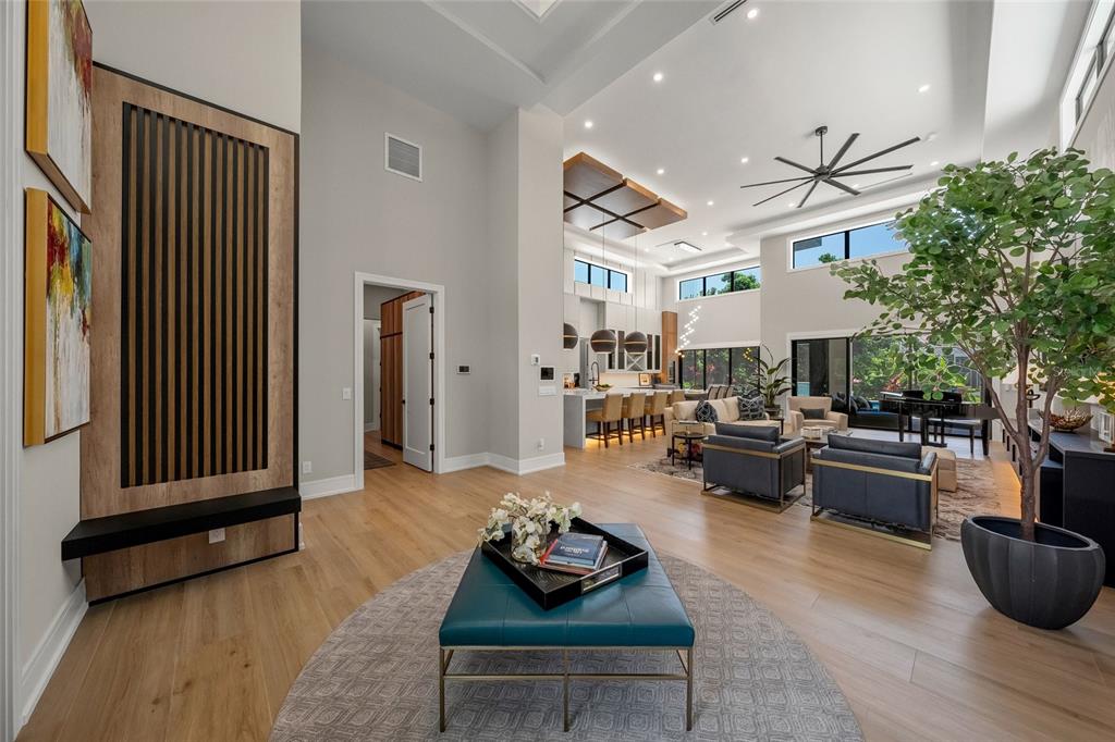 A spacious open-concept living area features high ceilings, light wood floors, and a modern kitchen — 1555 EASTBROOK DRIVE, SARASOTA, FL