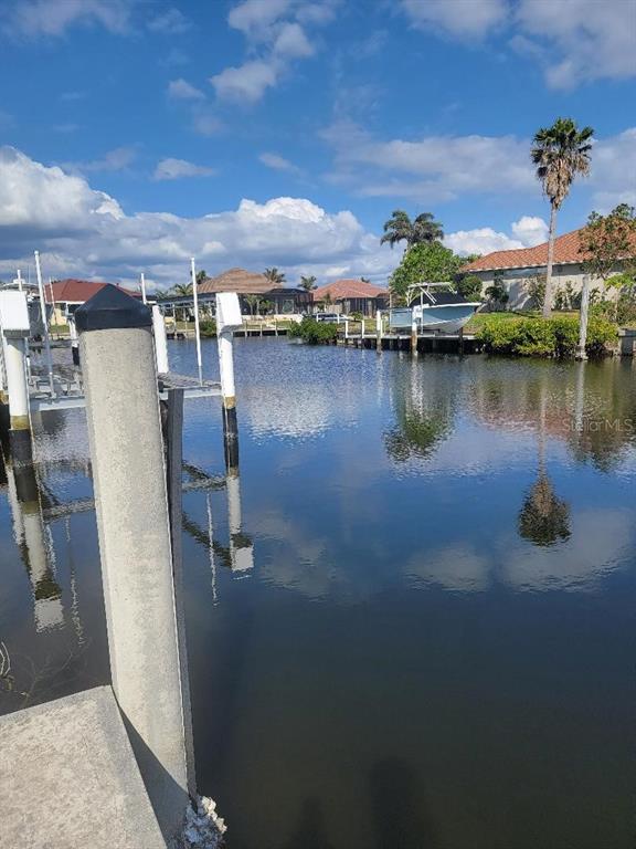 A view of a residential canal with a boat dock and a small motorboat — 5038 BAL HARBOR BOULEVARD, PUNTA GORDA, FL