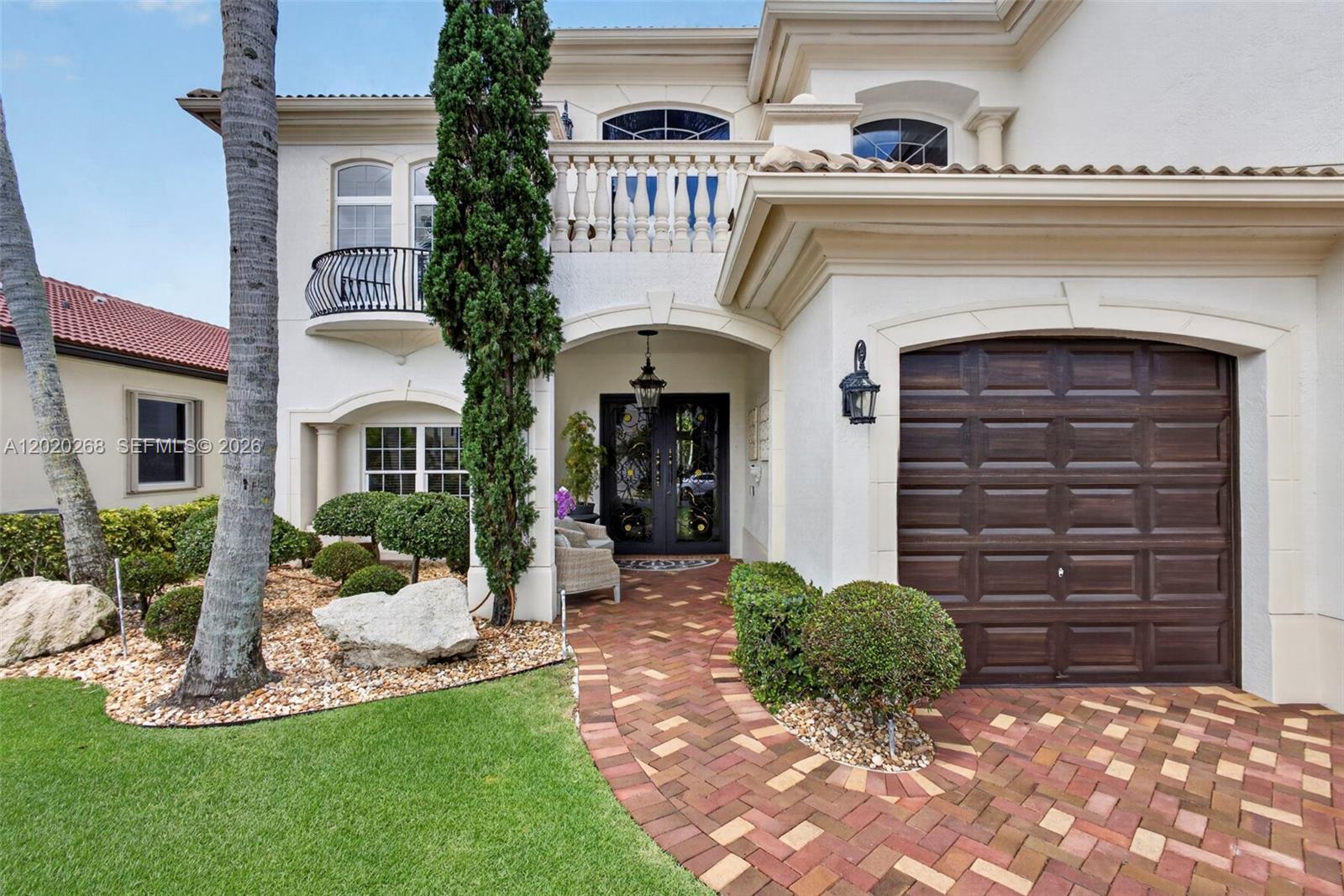 The exterior of a two-story stucco home features a brick walkway and a garage — 111 Abondance Dr, Palm Beach Gardens FL 33410, PALM BEACH GARDENS, FL