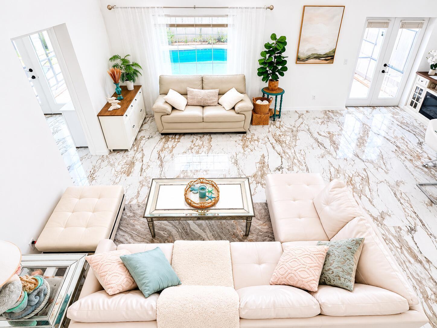 A bright living room features a large sectional, a loveseat, and polished marble-look tile flooring — 540 Sheridan Drive, Palm Harbor FL 34684, PALM HARBOR, FL