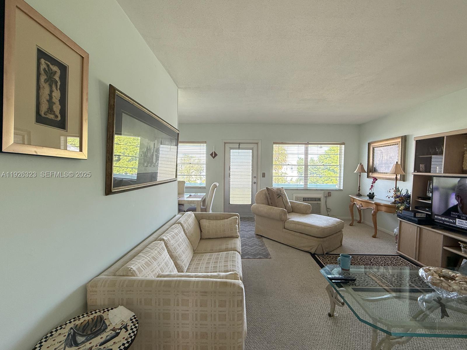 A living room features a beige sofa, a chaise lounge, and a glass coffee table — 90 Easthampton D # 90, West Palm Beach FL 33417, WEST PALM BEACH, FL