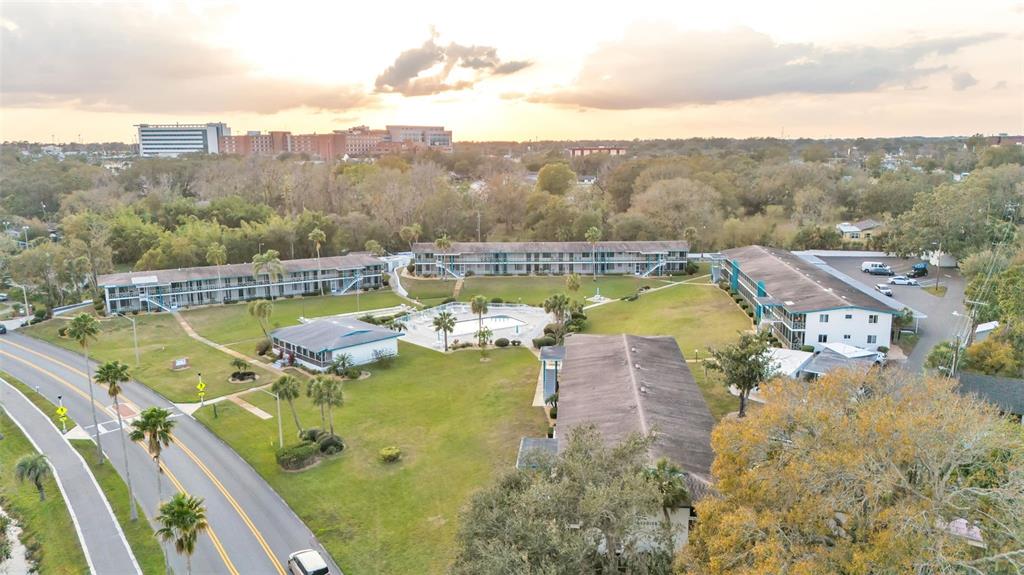 An aerial view shows a multi-building apartment complex with a central pool and parking lot — 1600 W LAKE PARKER DRIVE UNIT B9, LAKELAND, FL