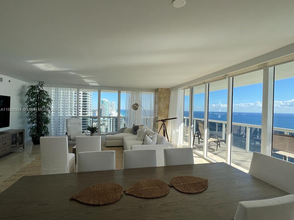 A bright living and dining area features floor-to-ceiling windows with ocean and city views — 1830 S Ocean Dr # 3101, Hallandale Beach FL 33009, HALLANDALE BEACH, FL