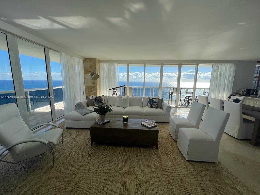 A bright living room features a white sectional, matching chairs, and floor-to-ceiling ocean views — 1830 S Ocean Dr # 3101, Hallandale Beach FL 33009, HALLANDALE BEACH, FL