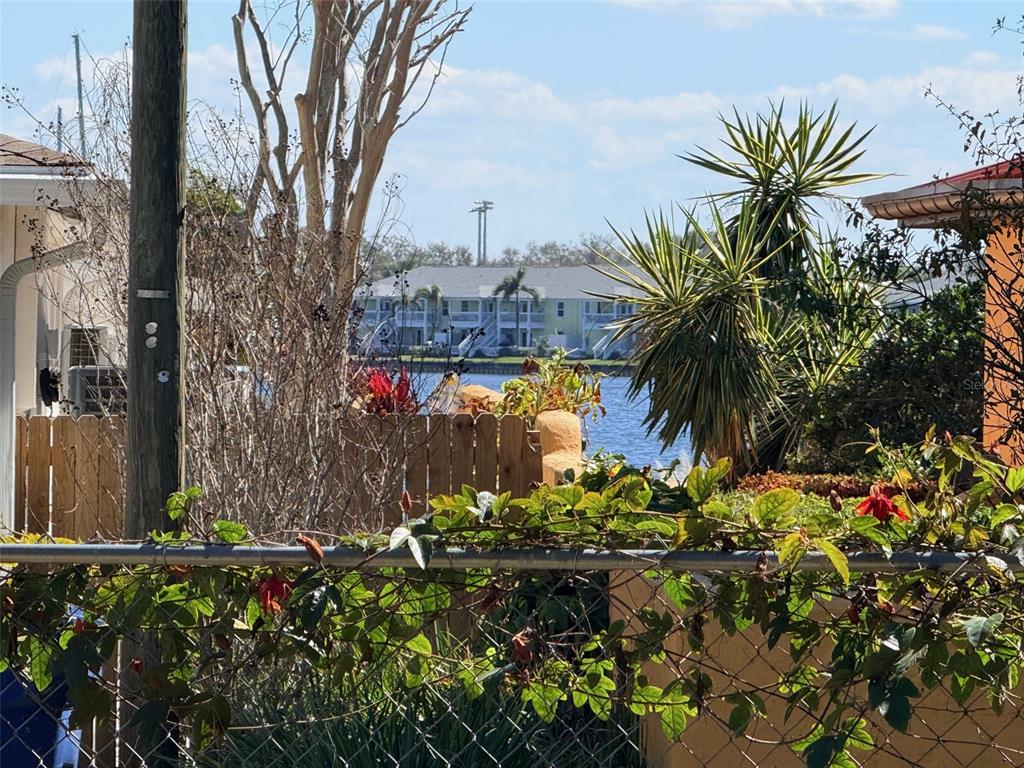 A view of a canal and apartment buildings seen through a chain-link fence — LING-A-MOR TERRACE S, ST PETERSBURG, FL