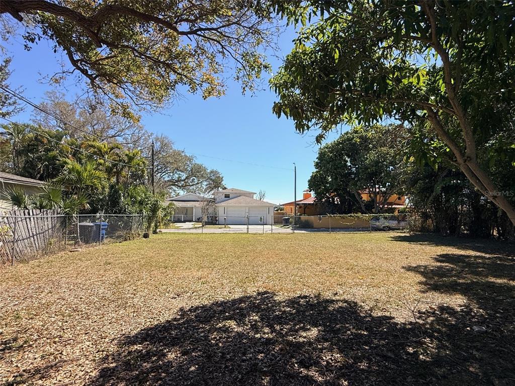 A vacant, grassy residential lot enclosed by a chain-link fence under a clear blue sky — LING-A-MOR TERRACE S, ST PETERSBURG, FL