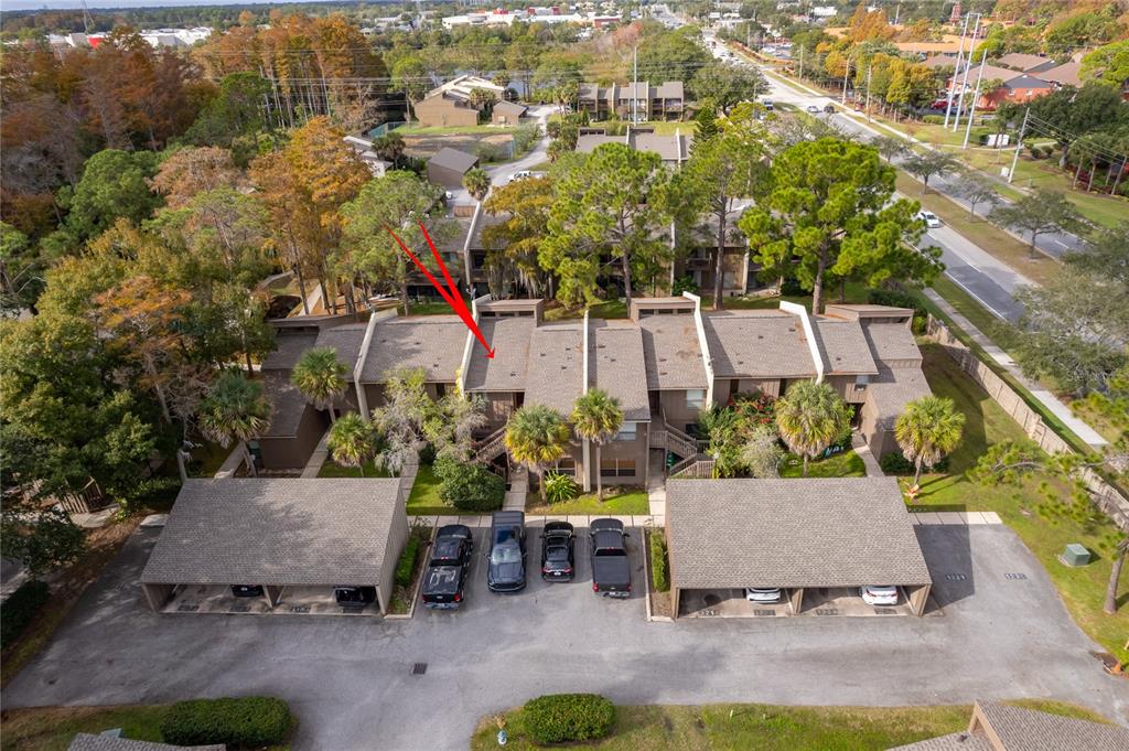 An aerial view shows a multi-unit townhouse complex with covered parking and surrounding trees — 4710 JASMINE CREEK LANE UNIT 1506, ORLANDO, FL