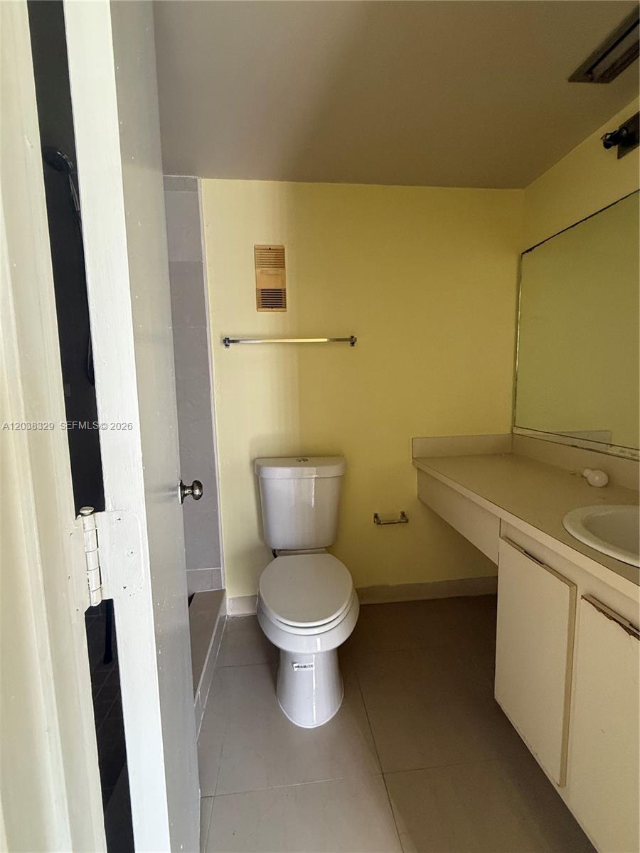 A bathroom features a toilet, a vanity with a sink, and a walk-in shower — 8740 N Sherman Cir # 402, Miramar FL 33025, MIRAMAR, FL