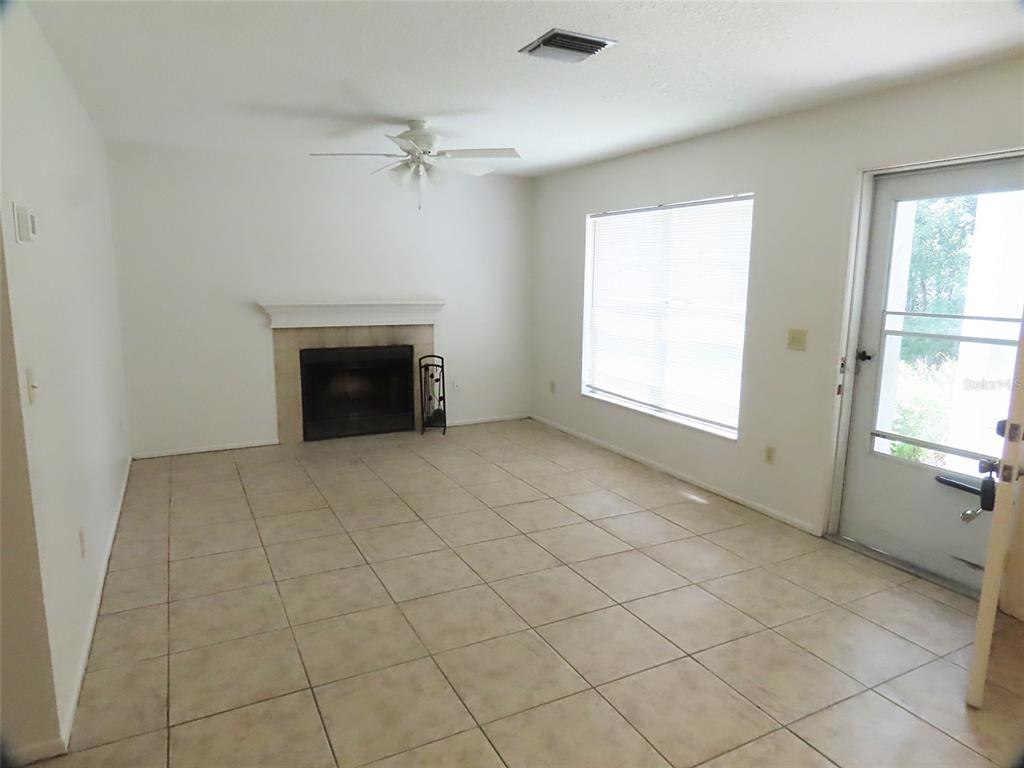 A living room features tile flooring, a fireplace, a ceiling fan, and a glass door — 104 NORTHLAKE DRIVE UNIT 104, SANFORD, FL