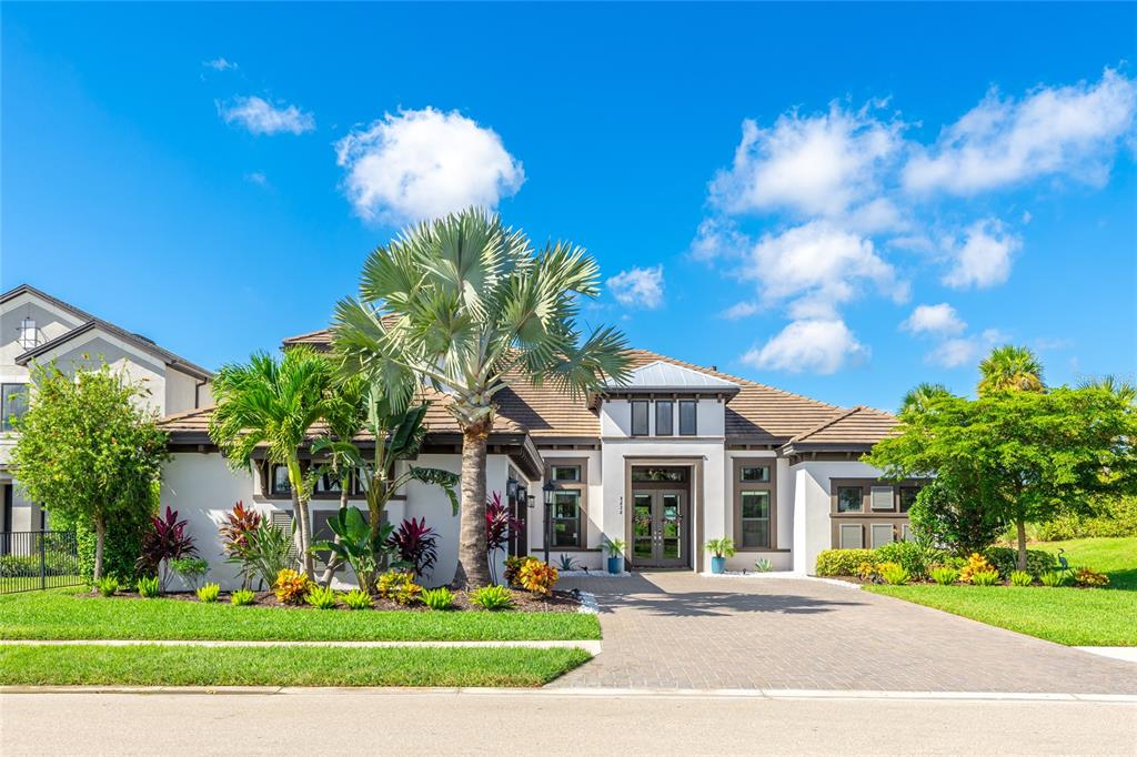 A single-story house with a paved driveway, palm trees, and a landscaped front yard — 8232 SUMMER NIGHT ROAD, SARASOTA, FL